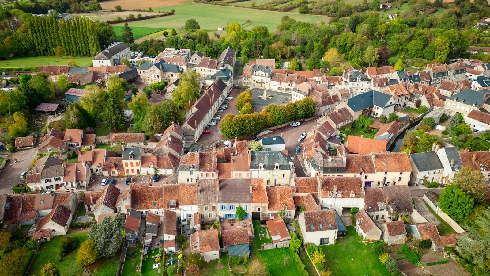 Vue aérienne d’un village français avec ses toitures, ses rues et la campagne autour